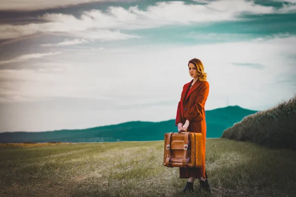 Vrouw op platteland met koffer — Stockfoto