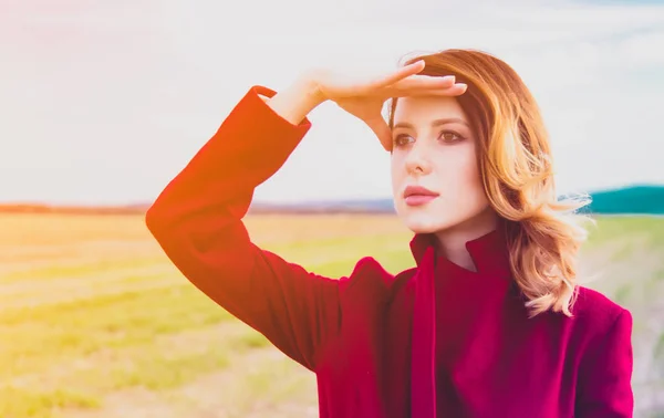 Woman in red coat at countryside field — Stock Photo, Image