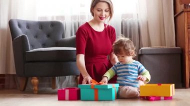 güzel anne oğluyla bir hediye kutuları arka planı sahne Noel için mutfakta kaydırma.