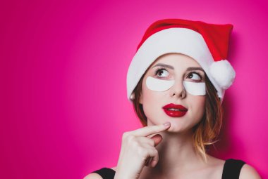 Gözlerinde izole pembe arka plan için göz bandı kullanan kadın