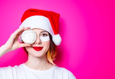 Santa Claus şapka izole pembe arka plan üzerine krema ile onun gözünde için göz bandı kullanan kadın. Genelde oldukları gibi doğal ve gerçek erkek portresi gibi görünüyor