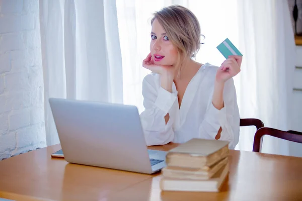 Жінка з ноутбуком і книгами, що тримає кредитну картку — стокове фото