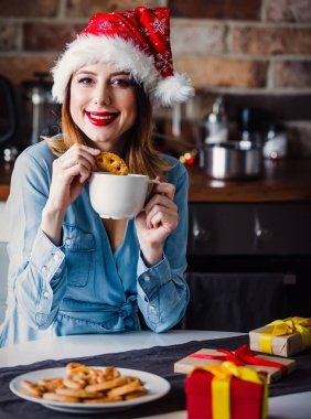 Güzel genç kadın mutfağa mevcut hediyeler ile oturuyordu. Noel zamanı