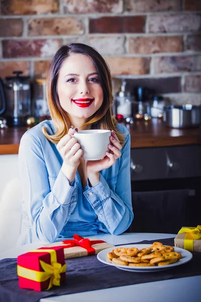 Hermosa joven sentada y en la cocina — Foto de Stock