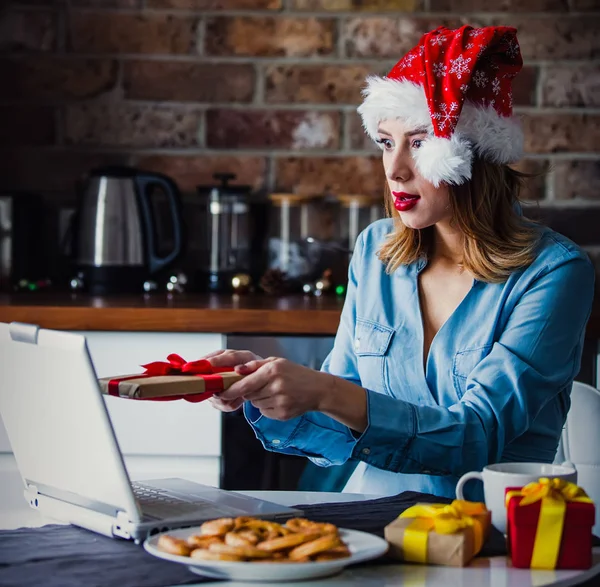 サンタ クロースの帽子座っているとノート パソコンでの作業の美しい若い女性の実業家 クリスマスの時期にスタートアップ企業との仕事の概念 — ストック写真
