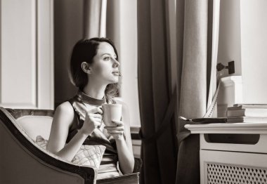 Kitap okuma sandalyede oturan genç Kızıl saçlı kadın.