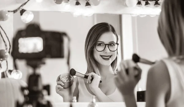 Женщина-блоггер применяет косметику на камеру — стоковое фото