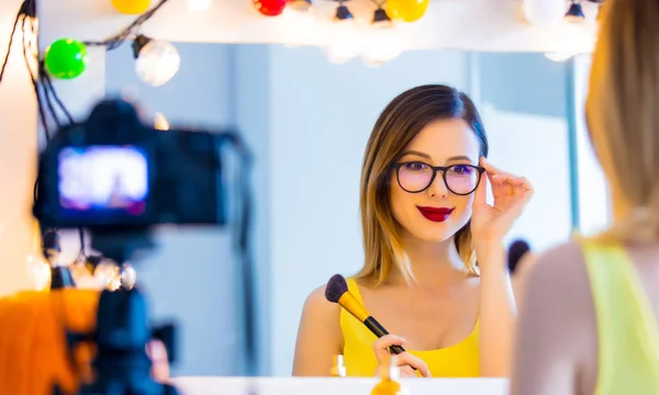 Blogger vrouw toepassen van cosmetica op camera — Stockfoto