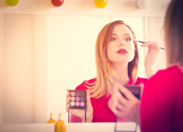 Jovem caucasiana aplicando cosméticos — Fotografia de Stock