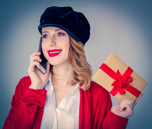 Woman in red cardigan and hat with gift box — Stock Photo, Image