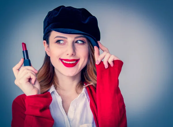 Vrouw in rode vest en muts met lippenstift — Stockfoto