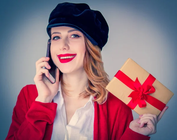 Женщина в красном кардигане и шляпе с подарочной коробкой — стоковое фото