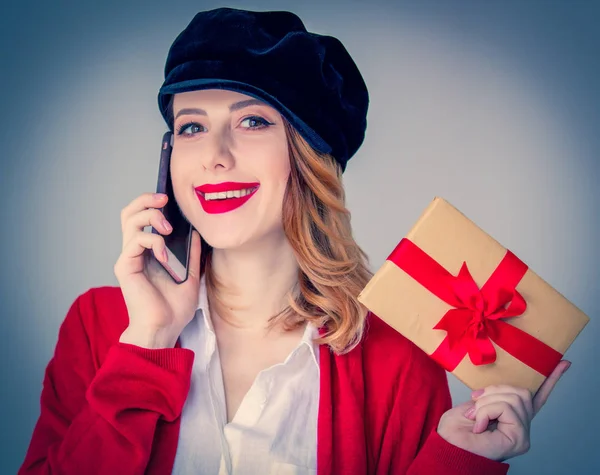 Frau in roter Strickjacke und Hut mit Geschenkbox — Stockfoto