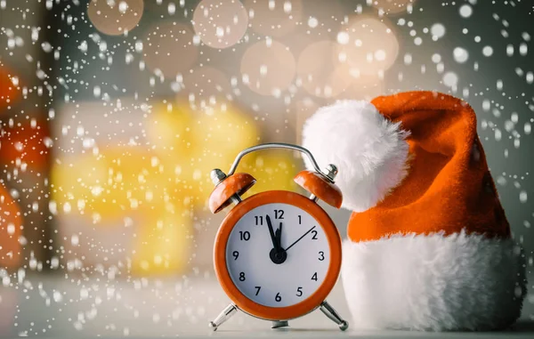 Vintage Alarm clock in Santa Claus hat with Christmas gift — Stock Photo, Image