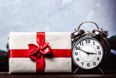 Noel hediyesi ile gri arka plan üzerinde ilmek ve retro çalar saat