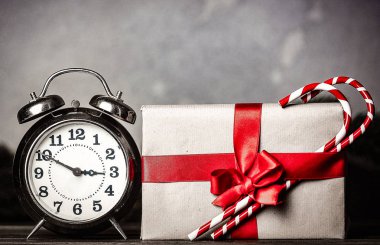 Noel hediyesi ile gri arka plan üzerinde lolipop ile ilmek ve retro çalar saat