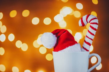 Beyaz fincan çay ya da kahve şeker koni ve Noel ışıkları arka plan üzerinde