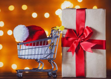 Alışveriş sepeti ve Noel ışıkları Noel Baba şapkasını arka plan