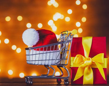 Alışveriş sepeti ve Noel ışıkları Noel Baba şapkasını arka plan