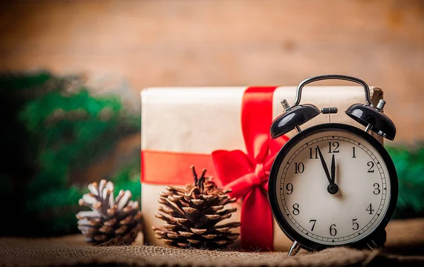 Weihnachtsgeschenk Und Tannenzapfen Mit Wecker Auf Jute Hintergrund — Stockfoto