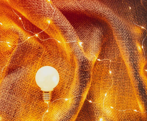 Ampul Lamba Çevresinde Peri Işıkları Jüt Arka Plan — Stok fotoğraf