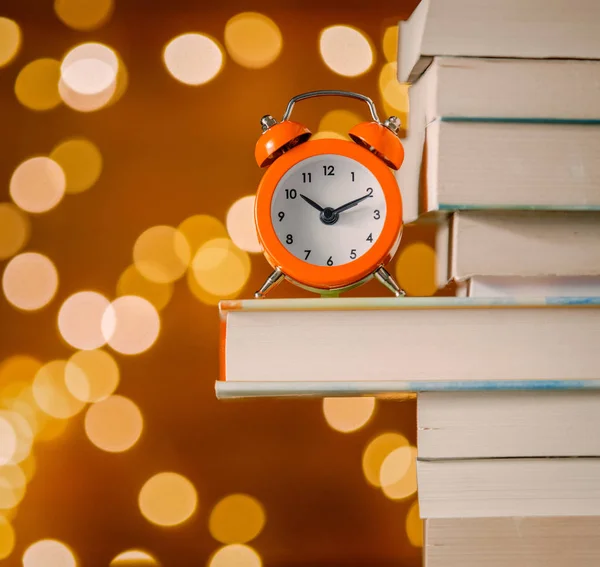 Vintage Wecker Und Stapel Von Büchern Auf Lichterketten Hintergrund — Stockfoto