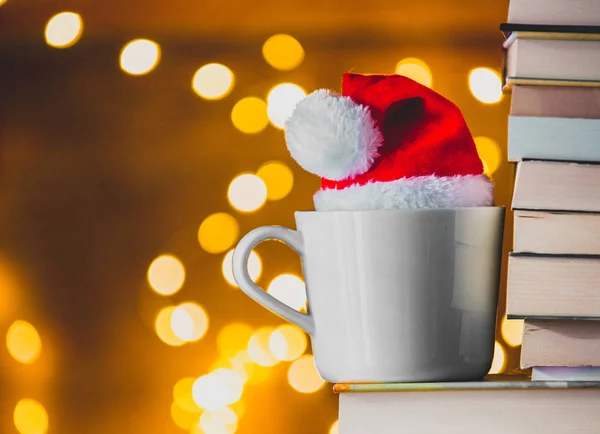 White Cup Christmas Hat Books Fairy Lights Background — Stock Photo, Image