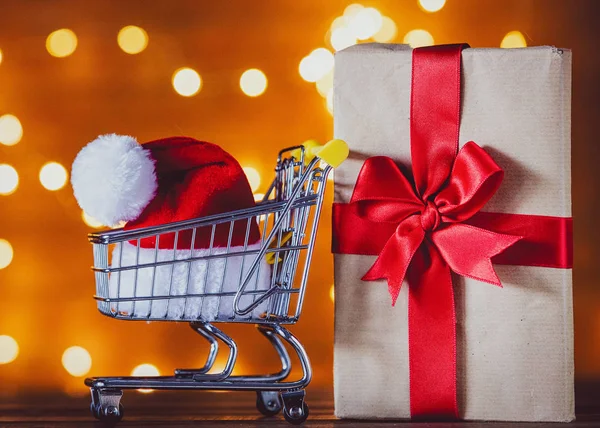Alışveriş sepeti ve Noel ışıkları Noel Baba şapkasını arka plan