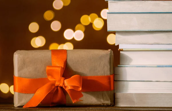 Рождественская подарочная коробка и куча книг с волшебными огнями — стоковое фото