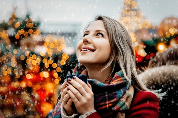 Flicka med kopp varm dryck på julmarknad — Stockfoto