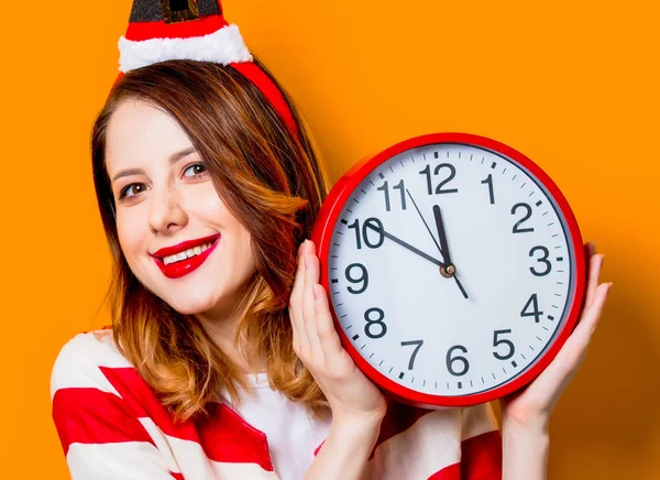 Mulher sorridente em chapéu de Papai Noel com relógio — Fotografia de Stock