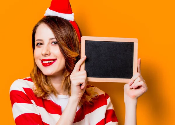 Vrouw in Kerstman hoed met schoolbord — Stockfoto