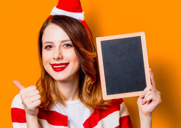 Femme dans le chapeau du Père Noël avec tableau noir — Photo