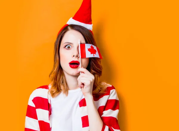 캐나다 국기와 함께 산타 클로스 모자에 있는 여자 — 스톡 사진