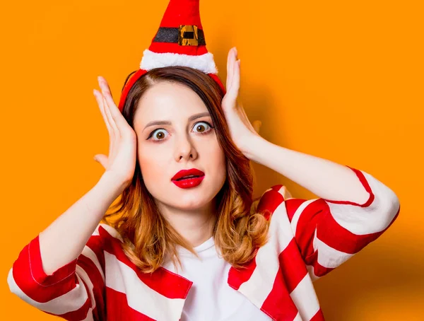 Portrét mladé překvapen rusovláska žena v klobouku Santa Claus — Stock fotografie
