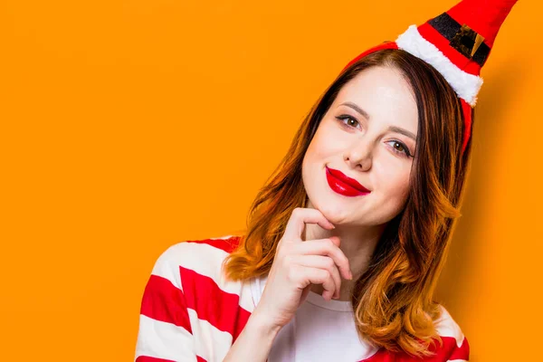 Retrato de jovem ruiva em chapéu de Papai Noel — Fotografia de Stock