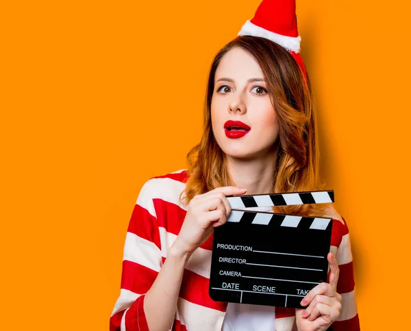 Donna in cappello Babbo Natale con clapperboard filmmaking — Foto Stock