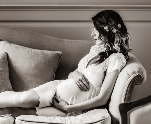 Young pregnant woman in white dress sitting — Stock Photo, Image