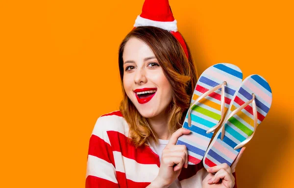 Vrouw in Kerstman hoed met slippers — Stockfoto