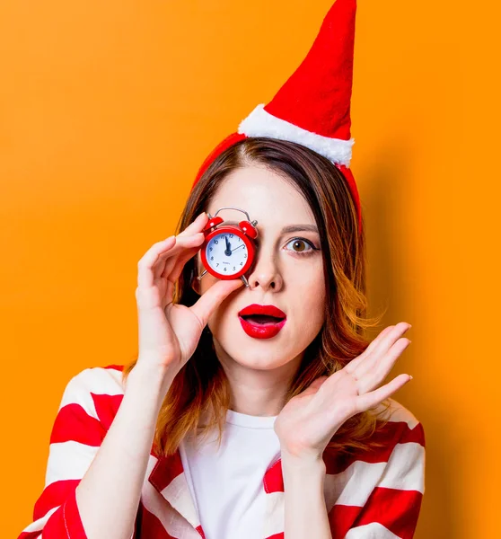 Mujer en Santa Claus sombrero con pequeño despertador —  Fotos de Stock