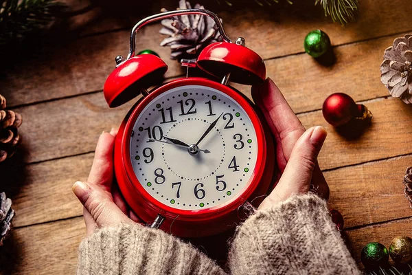 Female hands holding Christmas classic alarm clock — Stock Photo, Image