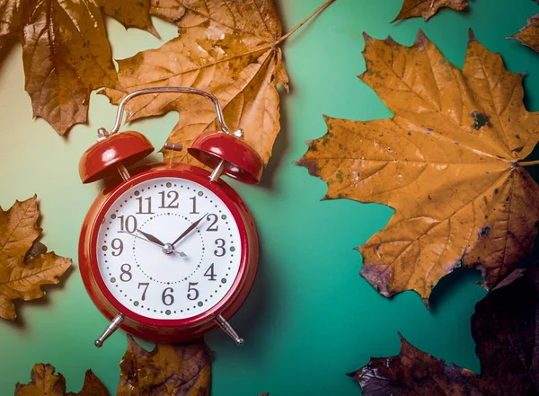 Reloj despertador vintage y hojas de arce — Foto de Stock