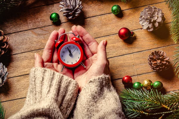 クリスマス古典的な目覚まし時計を保持している女性の手 — ストック写真