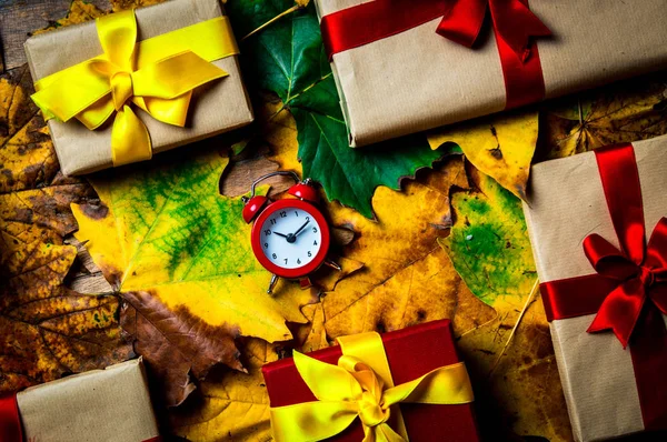 ビンテージの目覚まし時計とクリスマスのプレゼントとカエデの葉 — ストック写真