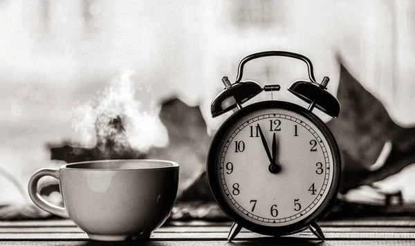 Retro alarm clock and maple leaves with rain drops — Stock Photo, Image