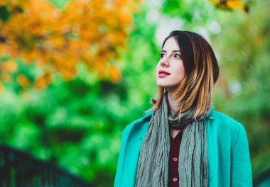 Mavi paltolu Tortum parkta oturan kadın