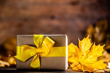 Hediye kutusu ile yay ve akçaağaç ahşap masada bırakır