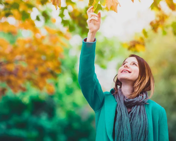 Жінка тримає жовтий кленовий лист дерева в автономному парку — стокове фото