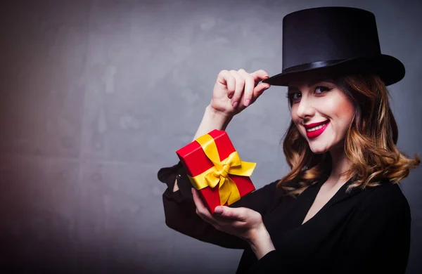 Руда дівчина у верхній шапці з подарунковою коробкою — стокове фото