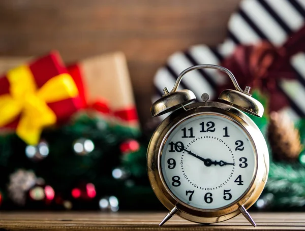 Relógio despertador na mesa de madeira com presentes de Natal — Fotografia de Stock